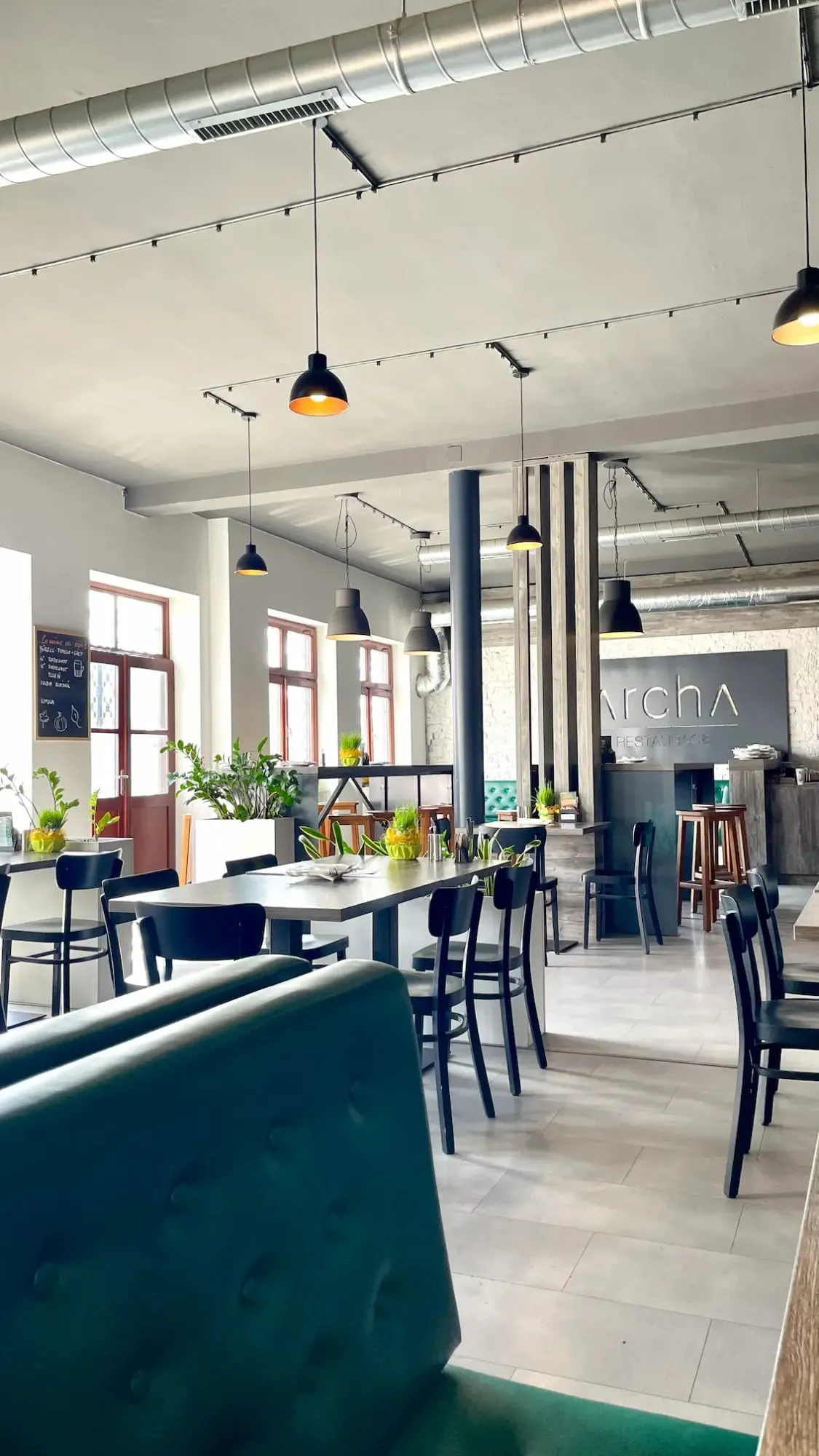 Interiér restaurace Archa — industriální styl, stoly a bar