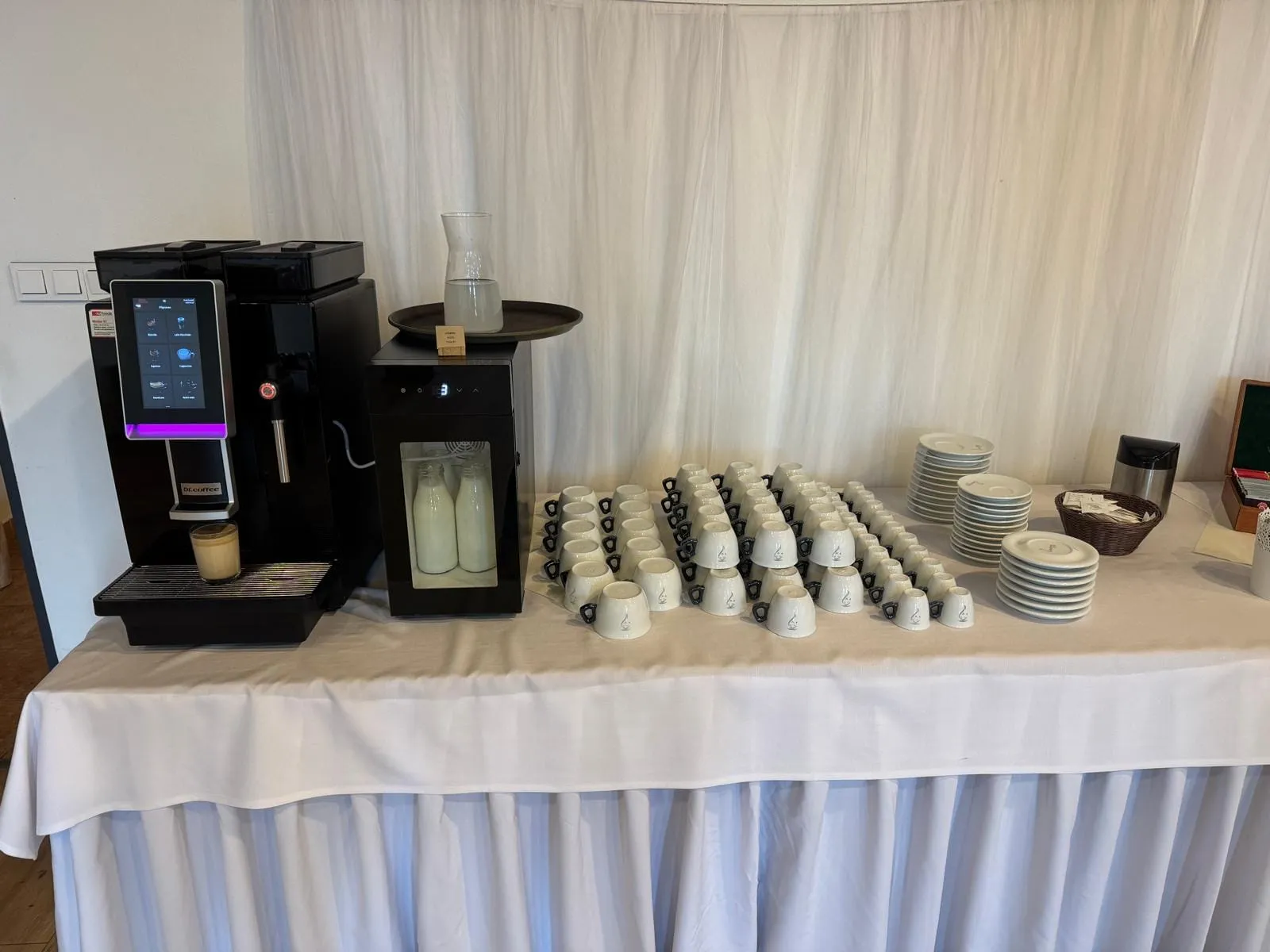 Kávovary a řady šálků připravené na coffee break