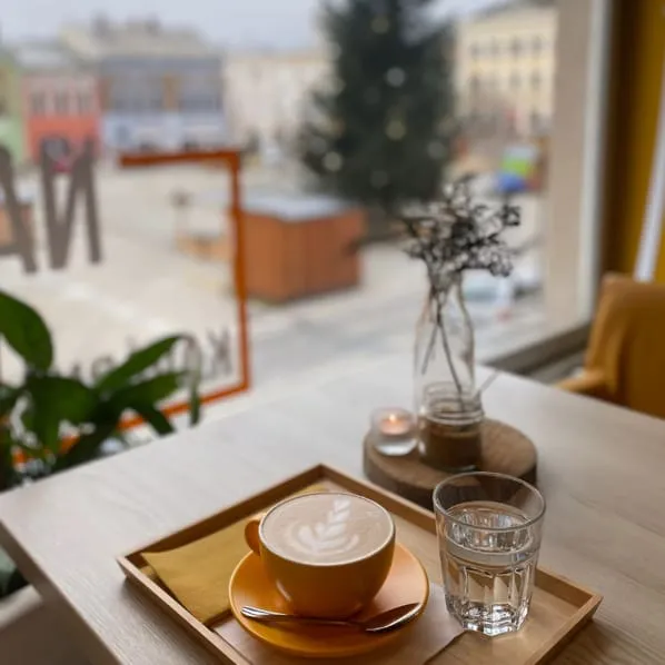 Cappuccino u okna kavárny Na hraně s výhledem na náměstí