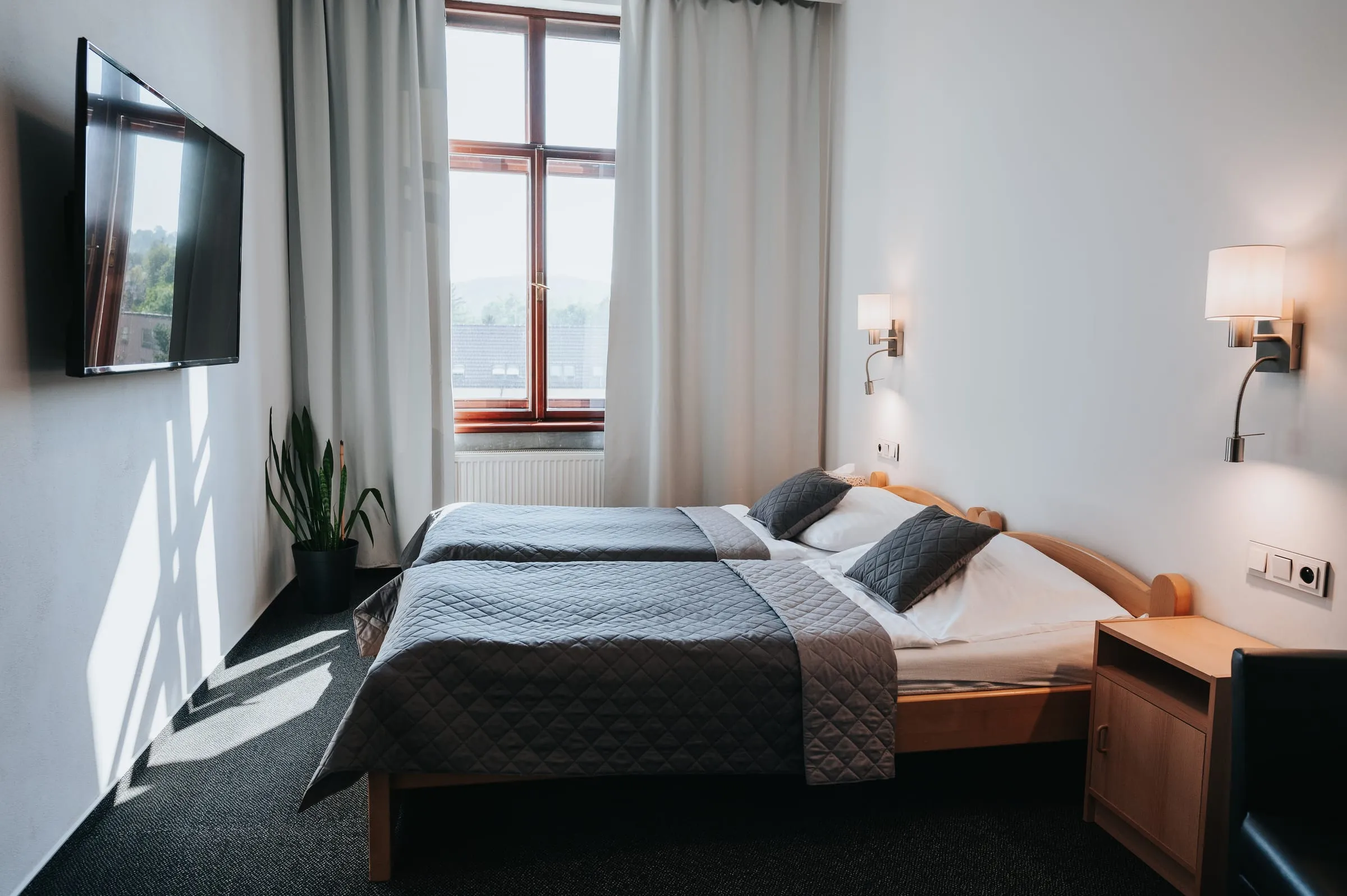 Pokoj Economy s postelí, televizí a oknem